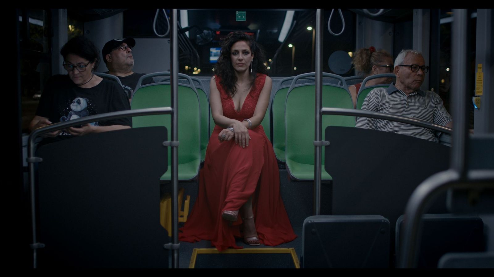 Alessia in abito rosso su un autobus notturno